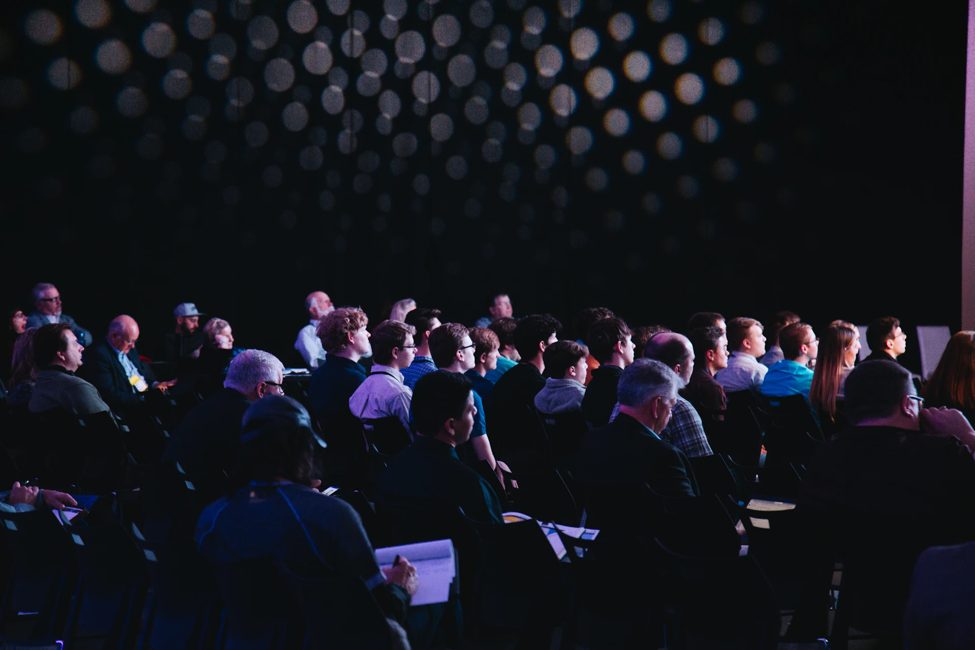 Conference audience facing a presentation stage